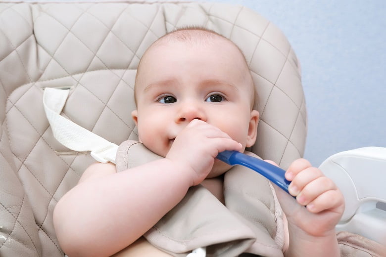 Bebé mordiendo cuchara de plástico